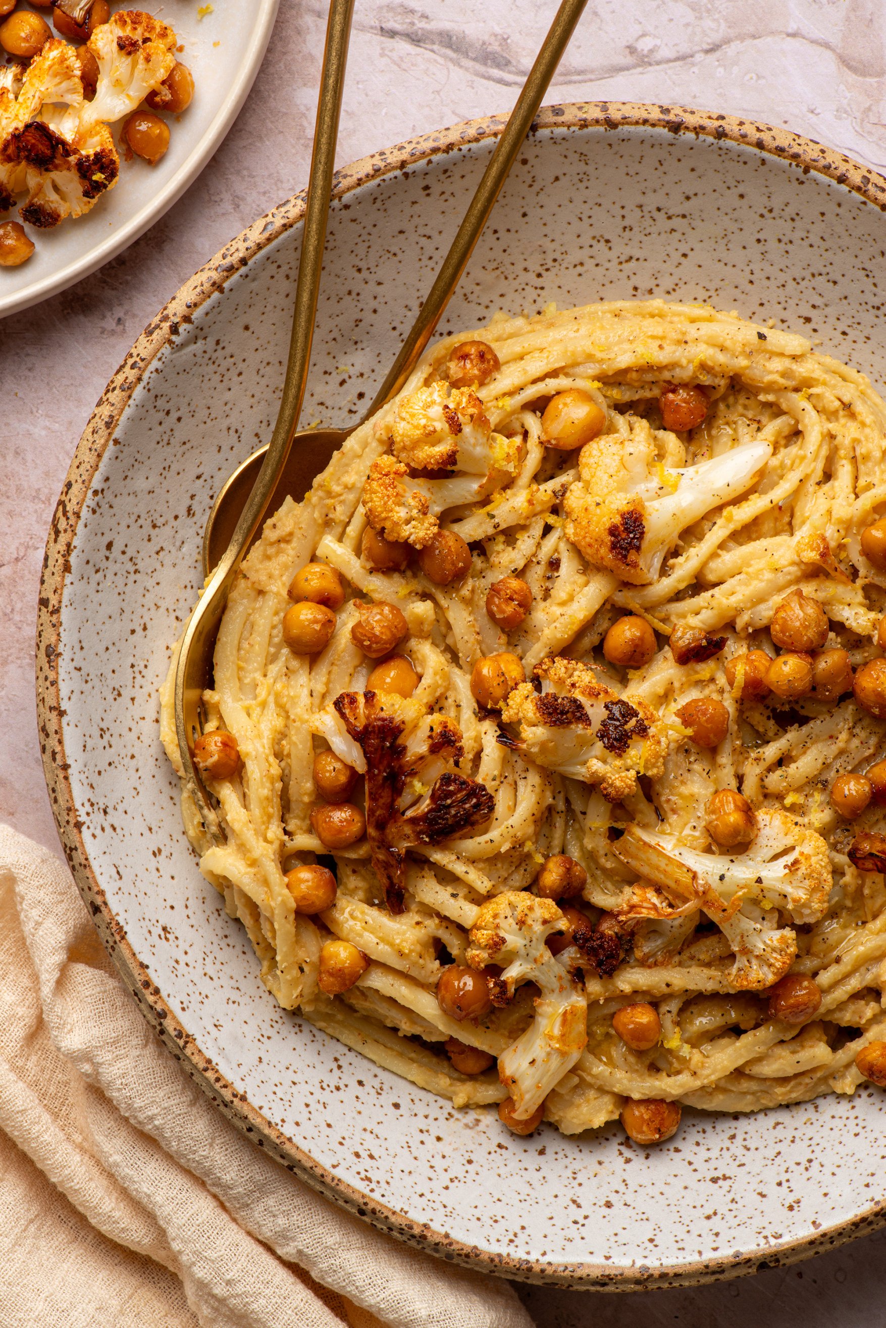 Food photography of roasted cauliflower and chickpeas over linguine
