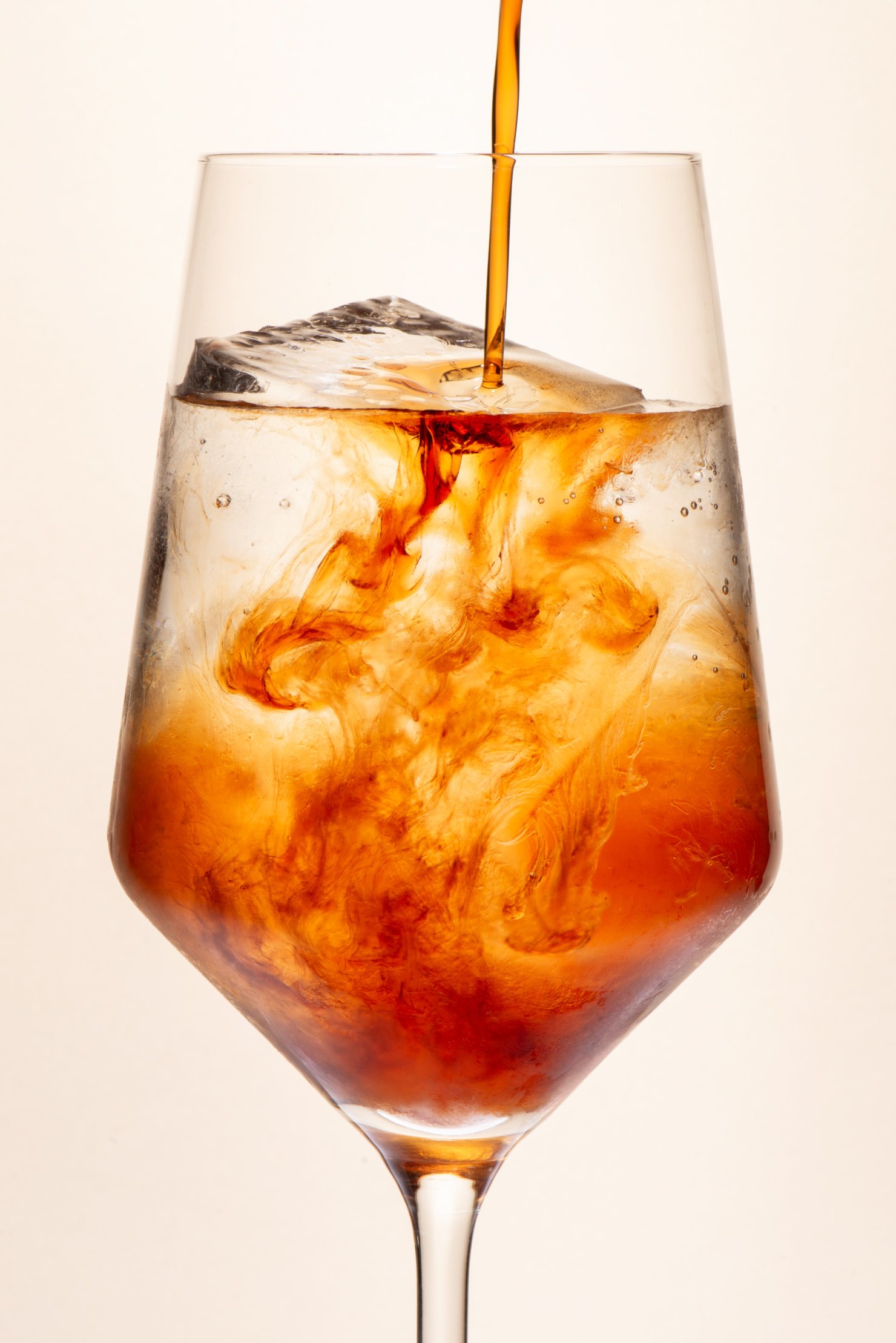 Cassis poured into drink with swirls frozen by photography