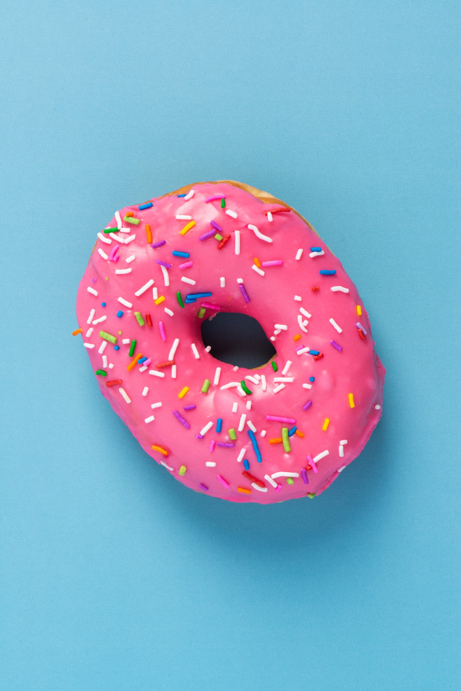 Pink sprinkle donut on blue background