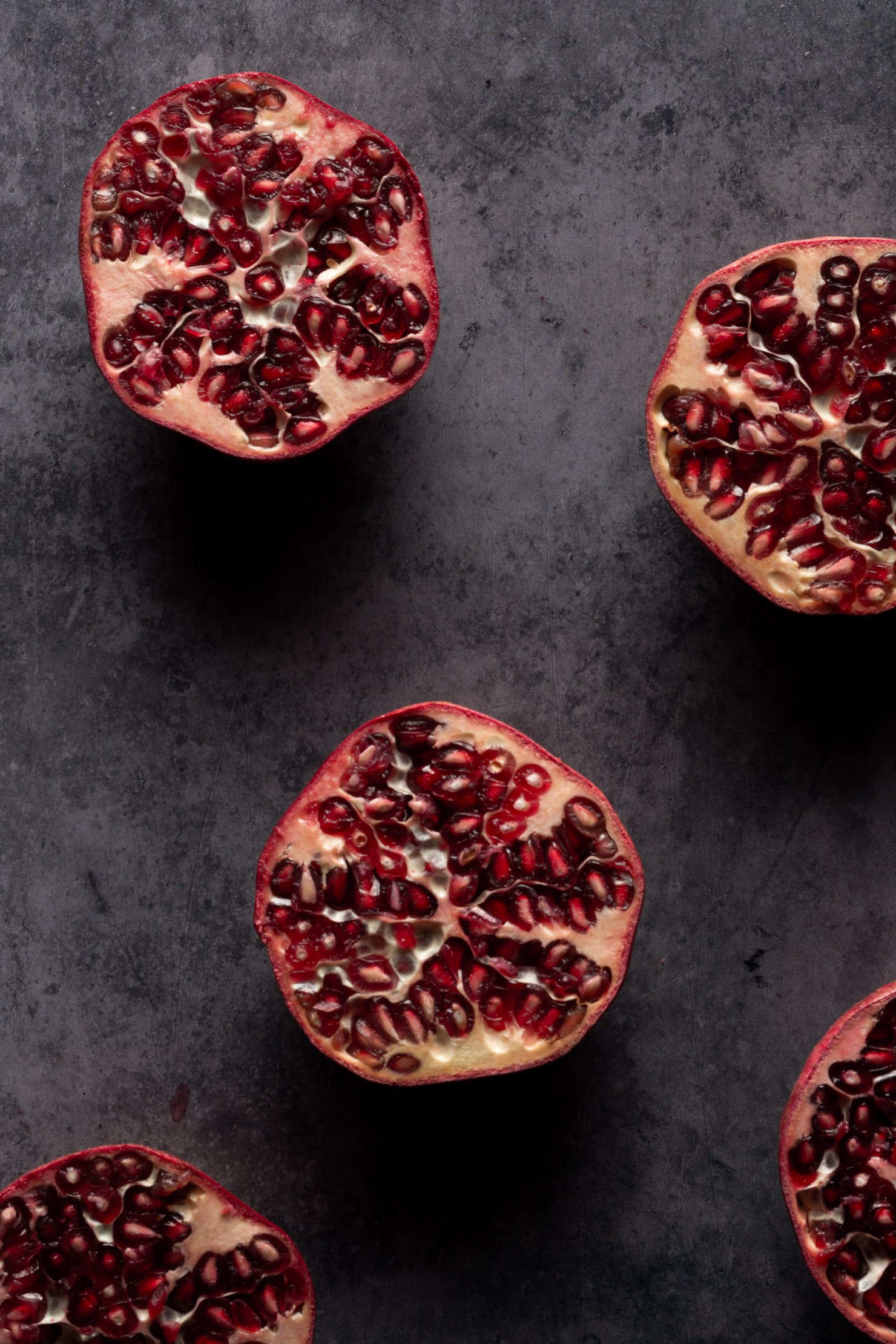 Dark and moody fresh pomegranates in food photography style